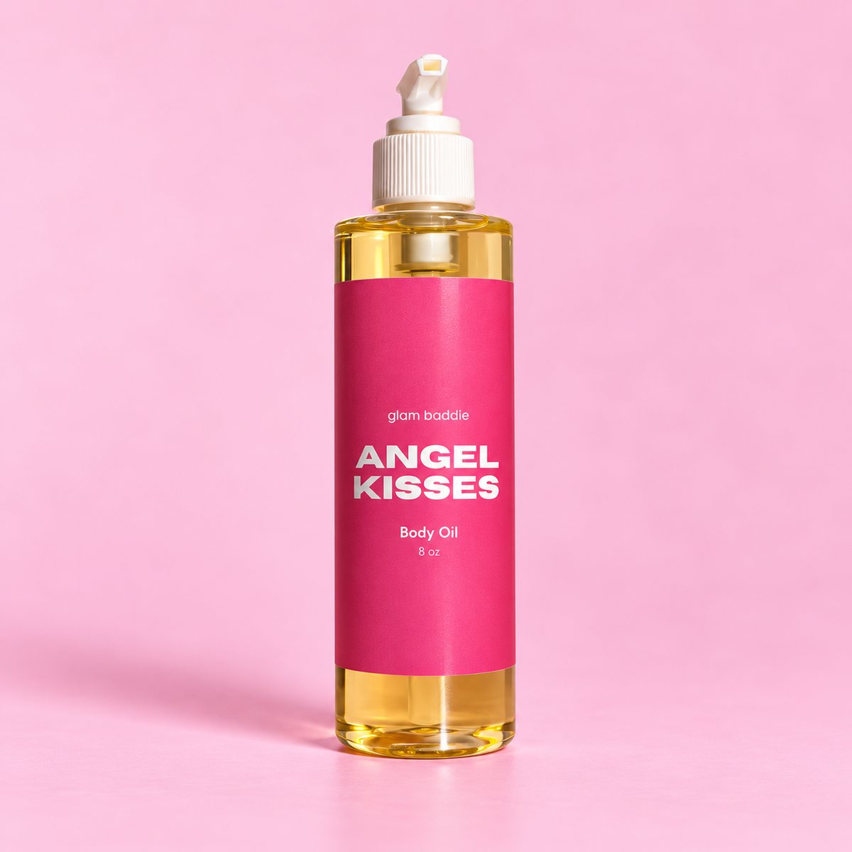 Glam Baddie Angel Kisses Body oil 8 oz bottle with pink label on a pink background.