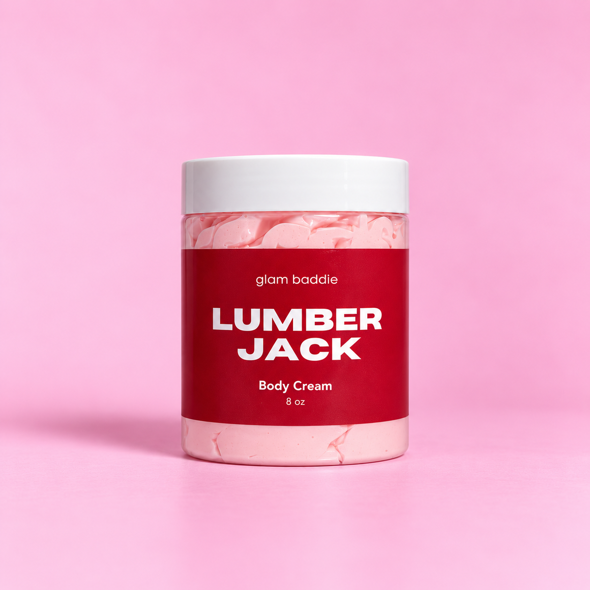 Glam Baddie Lumberjack Body Cream 8 oz jar with red label on a pink background.